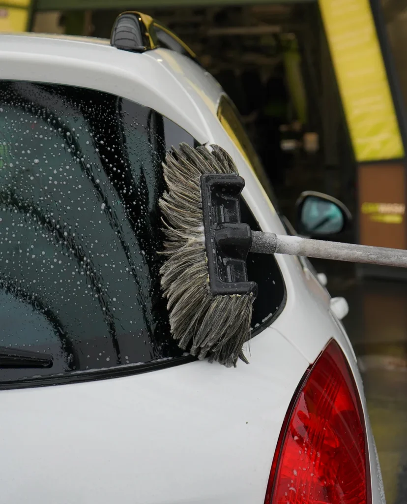 Borstel die een achter ruit aan het schoonmakenis