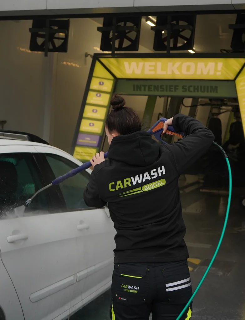 Medewerker van Carwash Boxtel die een auto aan het schoonmaken is.